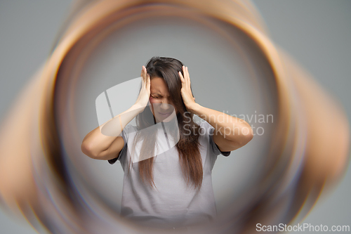 Image of Conceptual image of woman with headache surrounded by blurred tunnel effect