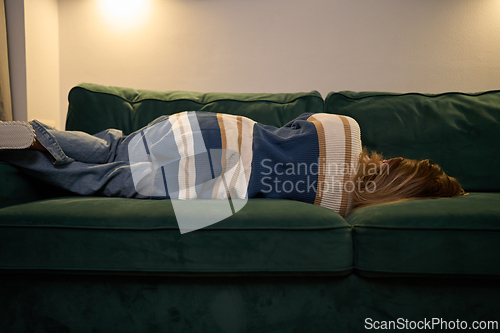 Image of Cozy solitude with woman resting on sofa under soft evening light