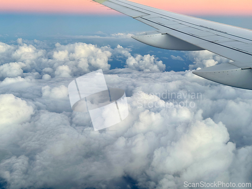 Image of Wing of an airplane flying above the clouds