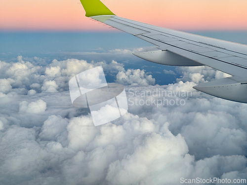 Image of Wing of an airplane flying above the clouds