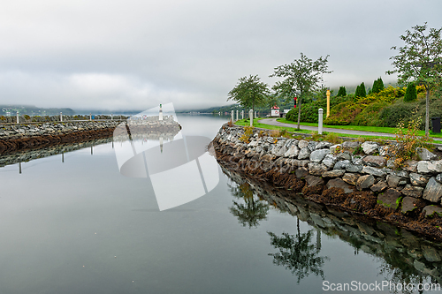 Image of Tranquil waters reflect surrounding greenery in a serene coastal