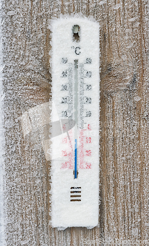 Image of Winter chill captured in frosty weather gauge on rustic wooden b