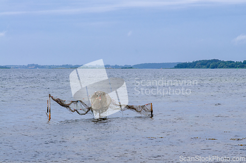 Image of Fishing nets gently sway in the tranquil waters under a serene s