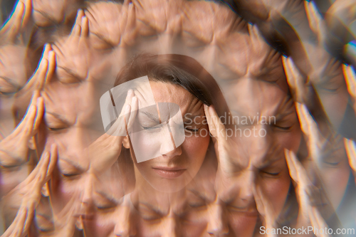 Image of Woman suffering from headache holding her head with multiple exposure effect