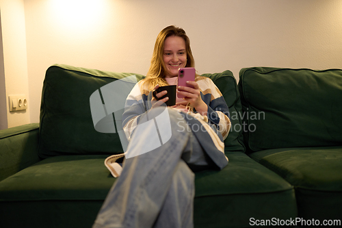 Image of Evening digital relaxation with woman smiling at smartphone