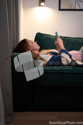 Image of Emotional exhaustion on sofa after day of screens and messages