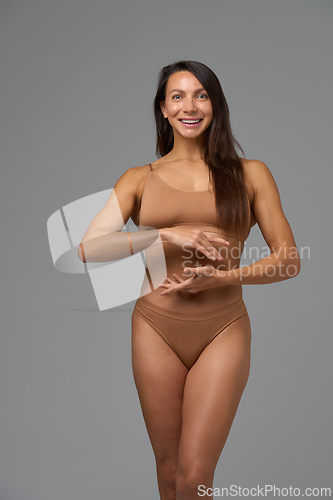 Image of Full-length portrait of confident athletic woman posing with calm expression
