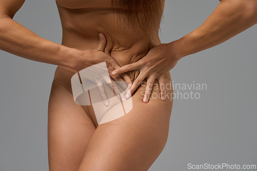 Image of Woman touching lower abdomen indicating menstrual pain or stomach discomfort