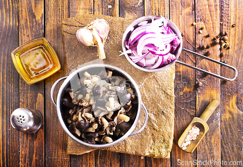 Image of pickled mushrooms in metal bowl on the table, next to spices. pickle mushrooms