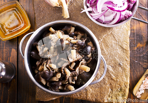 Image of pickled mushrooms in metal bowl on the table, next to spices. pickle mushrooms