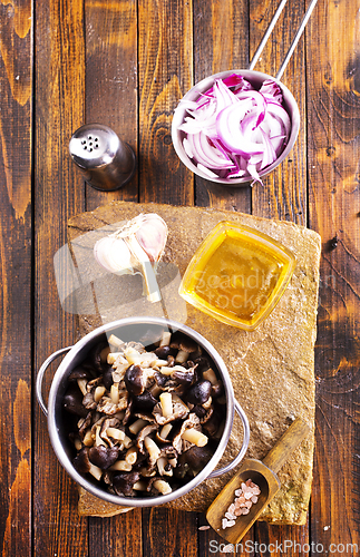 Image of pickled mushrooms in metal bowl on the table, next to spices. pickle mushrooms
