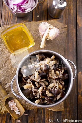 Image of pickled mushrooms in metal bowl on the table, next to spices. pickle mushrooms