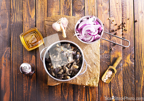 Image of pickled mushrooms in metal bowl on the table, next to spices. pickle mushrooms