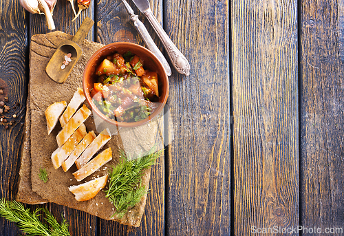 Image of chicken fillet on board with vegetable stew in bowl