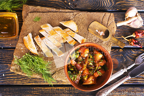 Image of chicken fillet on board with vegetable stew in bowl