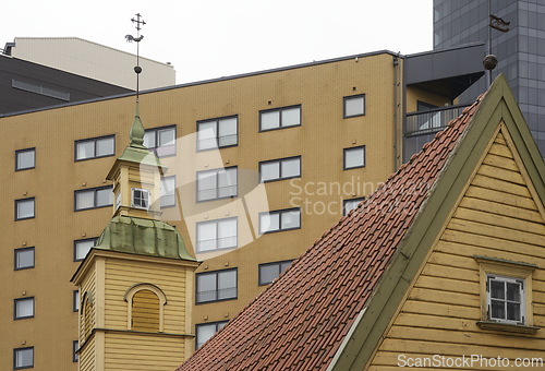 Image of wooden house with a tiled roof and a turret with a weather vane 
