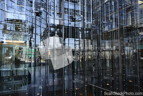 Image of elevators behind a glass wall in an office building 