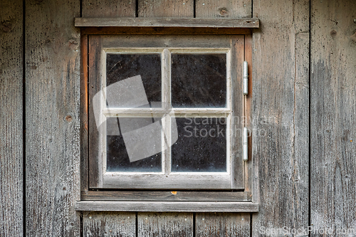 Image of Rustic wooden window framed by aged lumber, revealing a tranquil