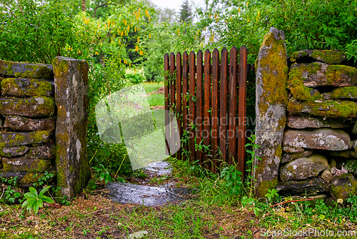 Image of Charming rustic gate leading to an enchanting garden filled with