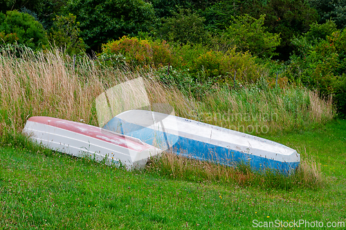 Image of Old boats resting peacefully in a lush green meadow near a seren