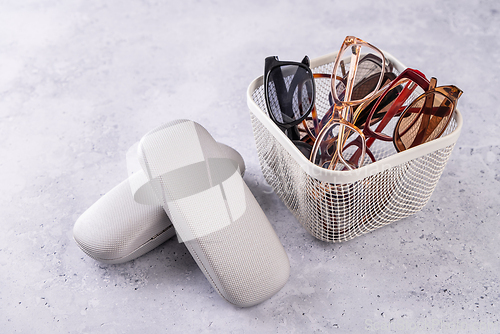 Image of Assortment of used eyeglasses and sunglasses in a basket, concept of recycling