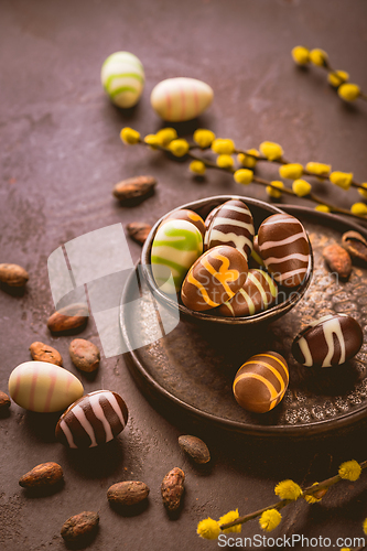 Image of Sweet chocolate eggs with cocoa beans in brown tone for Easter