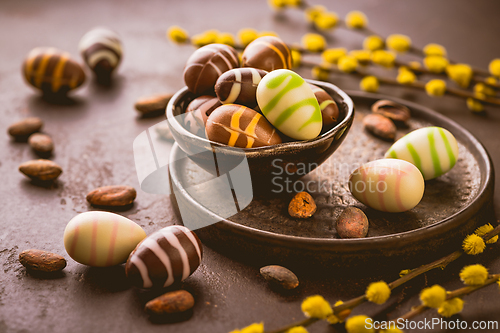 Image of Sweet chocolate eggs with cocoa beans in brown tone for Easter