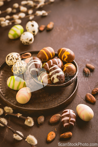 Image of Sweet chocolate eggs with cocoa beans in brown tone for Easter