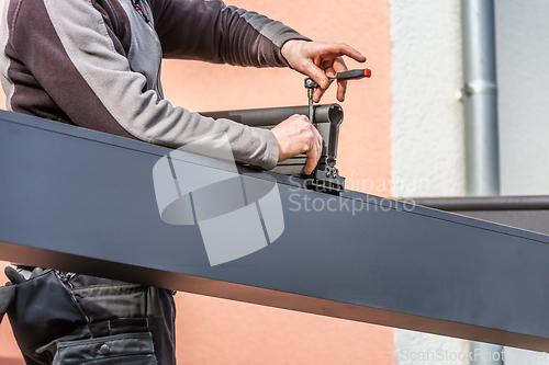 Image of Workers install patio roofing with steel and glass