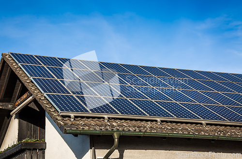 Image of New solar panels installed on sheet roof of modern house