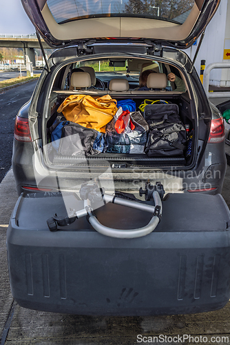 Image of Suitcases and bags in trunk of car ready to depart with additional cargo box