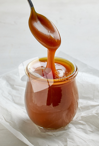 Image of freshly cooked homemade caramel sauce pouring in jar
