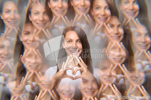 Image of Surreal creative portrait of woman making heart shape with fingers
