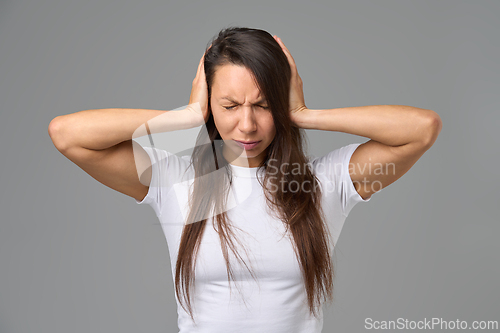 Image of Frustrated woman covering ears with hands showing stress and emotional