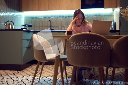 Image of Freelance woman feeling stressed while working on laptop at home