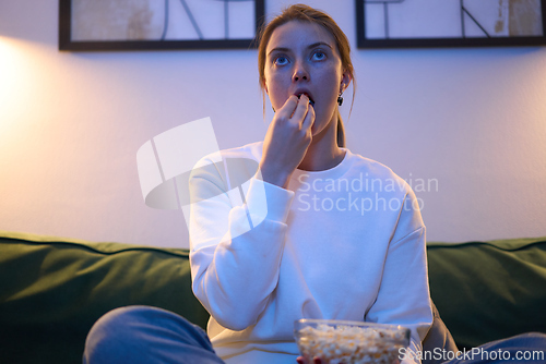 Image of Watching a Movie While Snacking in Cool Evening Light