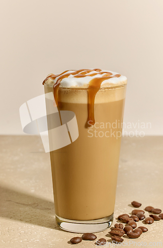 Image of glass of caramel latte with coffee beans