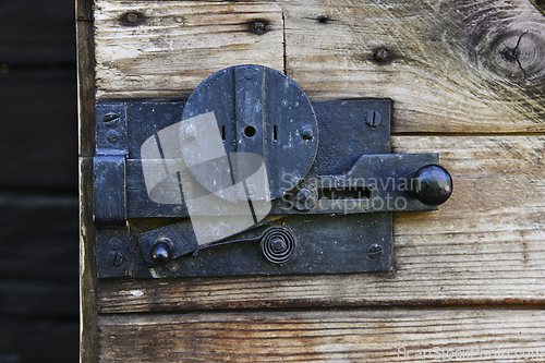Image of vintage metal lock on a wooden door