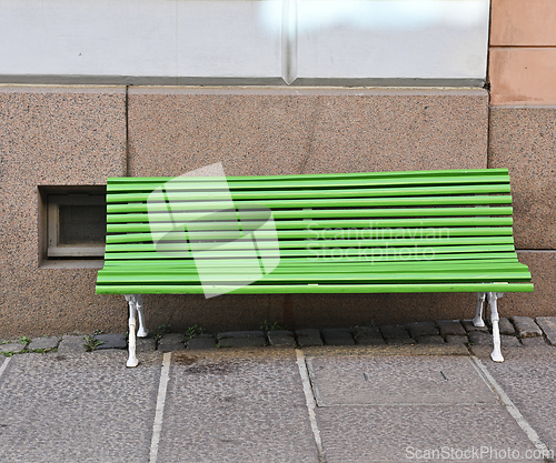 Image of bright green bench on granite pavement near the granite foundati