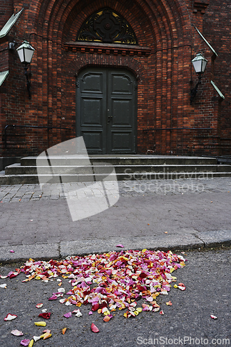 Image of rose petals on the asphalt near the entrance to a German church 