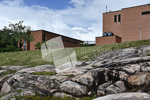 Image of brick buildings atop rocky hill under a blue sky 