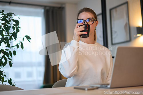 Image of Morning Sip and Screen Time in a Cozy Workspace