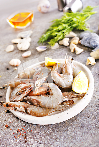 Image of Uncooked Raw peeled tiger white shrimp prawn. Gray background.