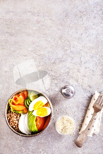 Image of Healthy vegan nutritious bowl with buckwheat. Salad of avocado, salmon, buckwheat, egg and tomato