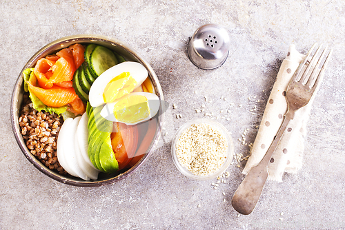 Image of Healthy vegan nutritious bowl with buckwheat. Salad of avocado, salmon, buckwheat, egg and tomato