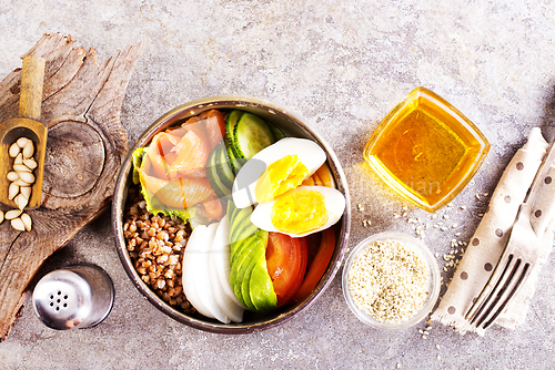 Image of Healthy vegan nutritious bowl with buckwheat. Salad of avocado, salmon, buckwheat, egg and tomato