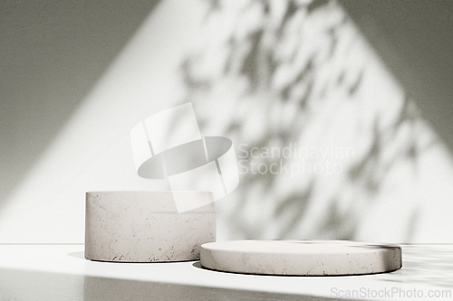 Image of Luxury marble table with plant shadow on white wall and stone po