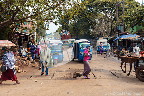 Image of Everyday life capturing a mix of motorized and animal-drawn vehicles in the bustling town center. Fenote Selam, Ethiopia