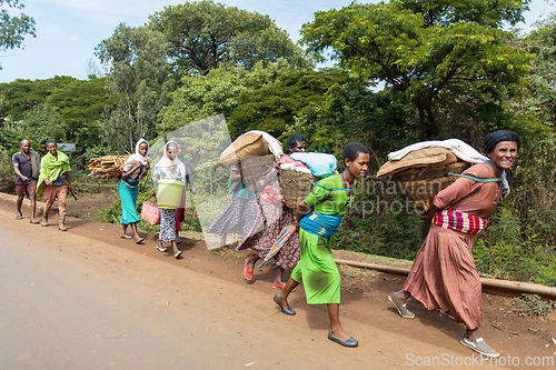 Image of Everyday scene capturing the physical effort of transporting market goods on the dusty road outside Fenote Selam.