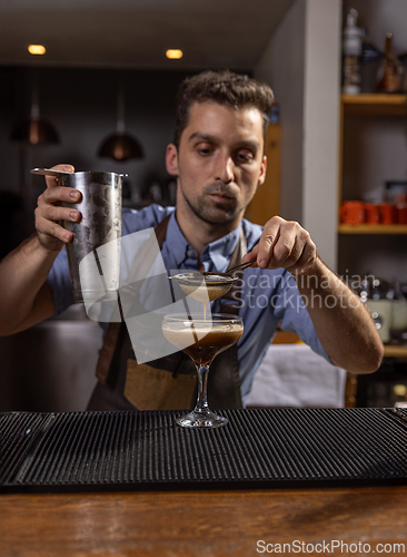 Image of Bartender carefully pouring an ingredient